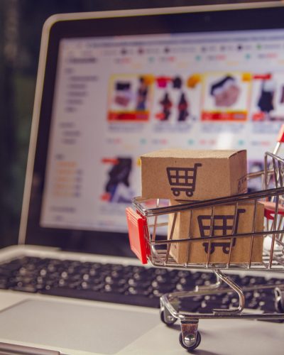 Shopping online concept - Parcel or Paper cartons with a shopping cart logo in a trolley on a laptop keyboard. Shopping service on The online web. offers home delivery.