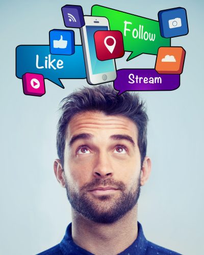 Studio shot of a handsome young man looking up at social media bubbles.